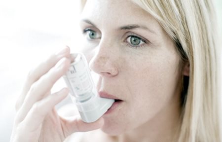Een vrouw die een inhalator gebruikt.