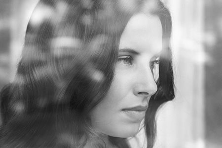 Een vrouw kijkt uit het raam