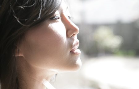 Een Aziatische vrouw kijkt in de zon