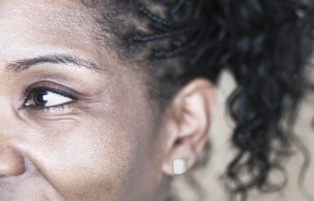 Het gezicht van een vrouw met een donkere huid