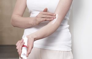 Een vrouw brengt Eucerin AtopiControl Intensief Kalmerende Crème op haar elleboogholte aan.