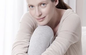 Een vrouw in een ontspannen houding met een gebogen been.