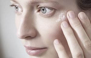 Een vrouw raakt haar gezicht met de hand aan.