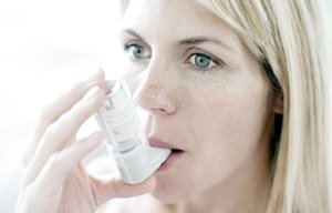 Een vrouw gebruikt een inhalator.