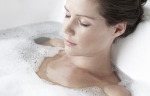 Een vrouw ontspant zich in een schuimbad