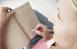 Een vrouw schrijft iets op haar tablet.