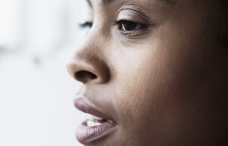 Het gezicht van een vrouw met een donkere huid