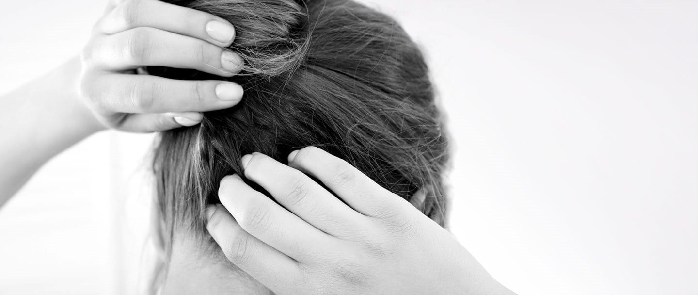 Een vrouw krabt aan haar jeukende hoofdhuid