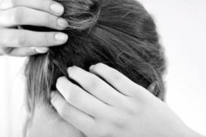 Een vrouw krabt aan haar jeukende hoofdhuid