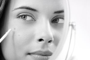 Een Eucerin-model gebruikt een camouflagestift tegen donkere vlekken